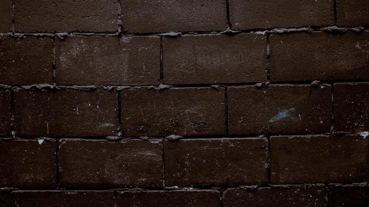 Close-up of a dark brick wall texture, perfect for backgrounds or design elements.