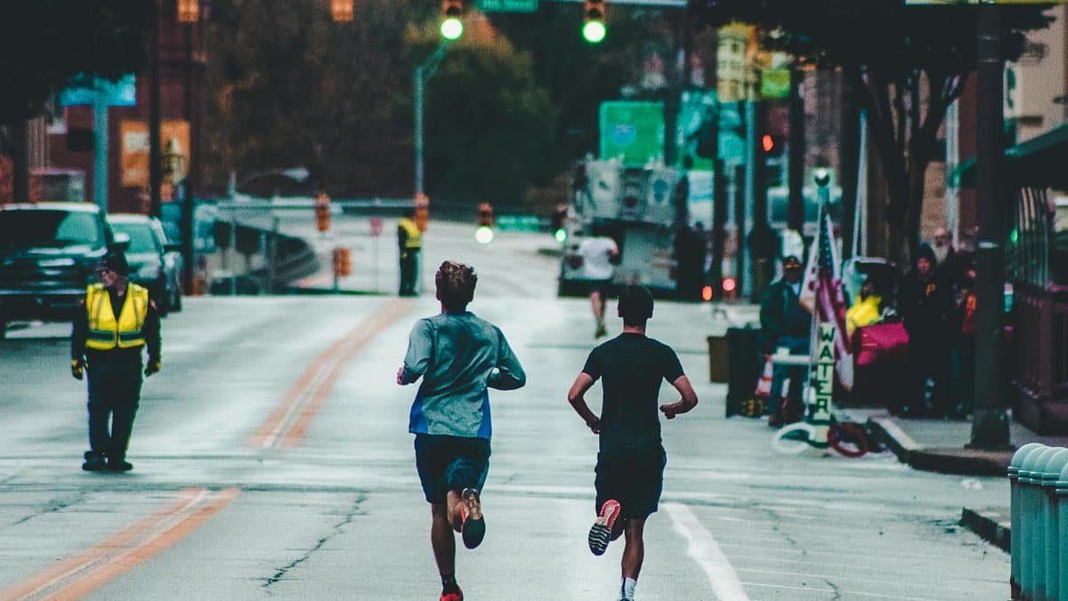 Athletes running a marathon on a street in Wheeling, WV, showcasing urban exercise and lifestyle.