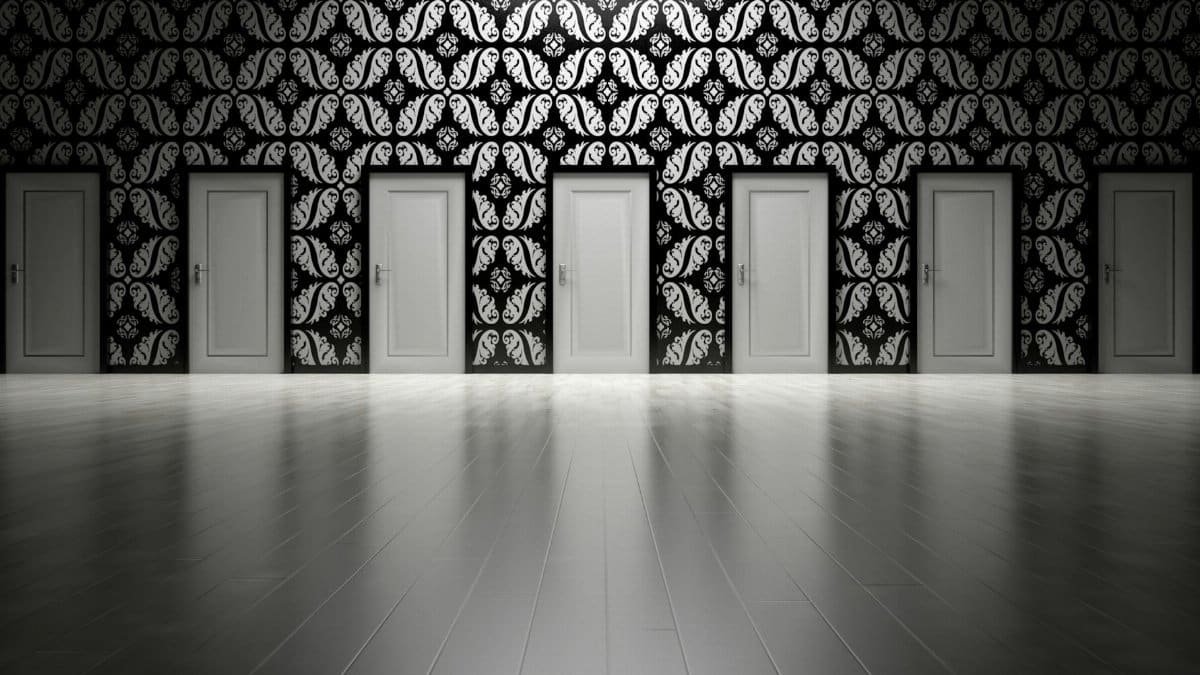 Five closed doors in a black and white ornate hallway symbolizing opportunities and decisions.