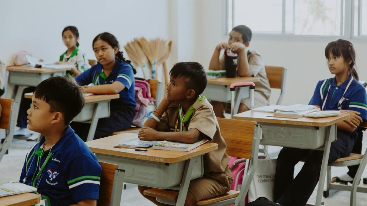 Children attentively listening in a classroom setting, focused on learning and education.