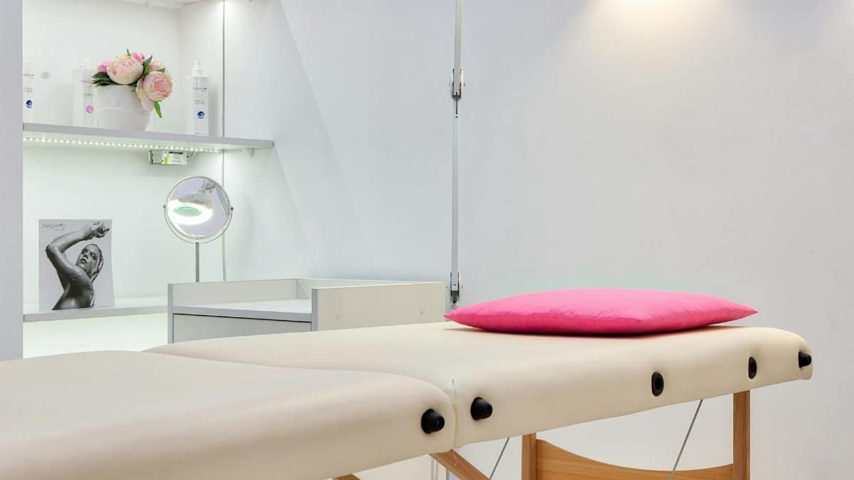 Interior of modern beauty office with couch for skincare procedures under glowing light