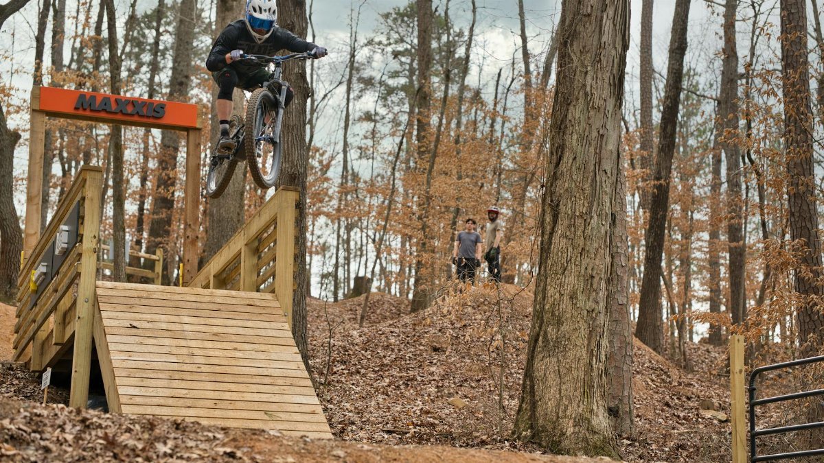 Thrilling mountain bike jump over a ramp in a forest trail in Roswell, GA.