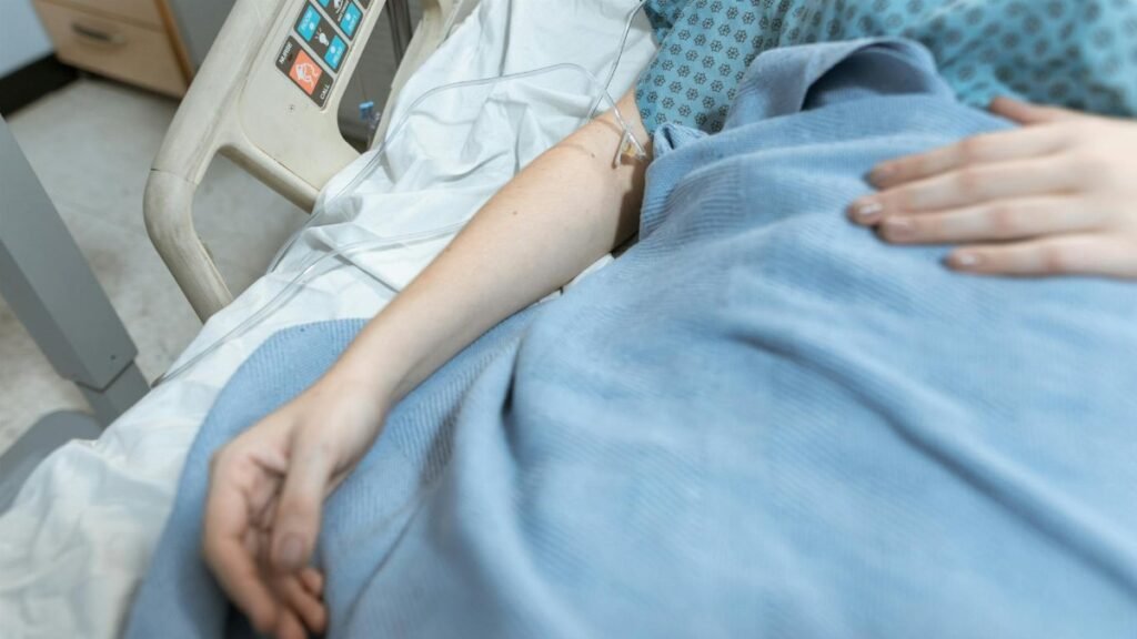 A close-up of a patient in a hospital bed receiving intravenous treatment, conveying healthcare and recovery.
