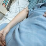 A close-up of a patient in a hospital bed receiving intravenous treatment, conveying healthcare and recovery.