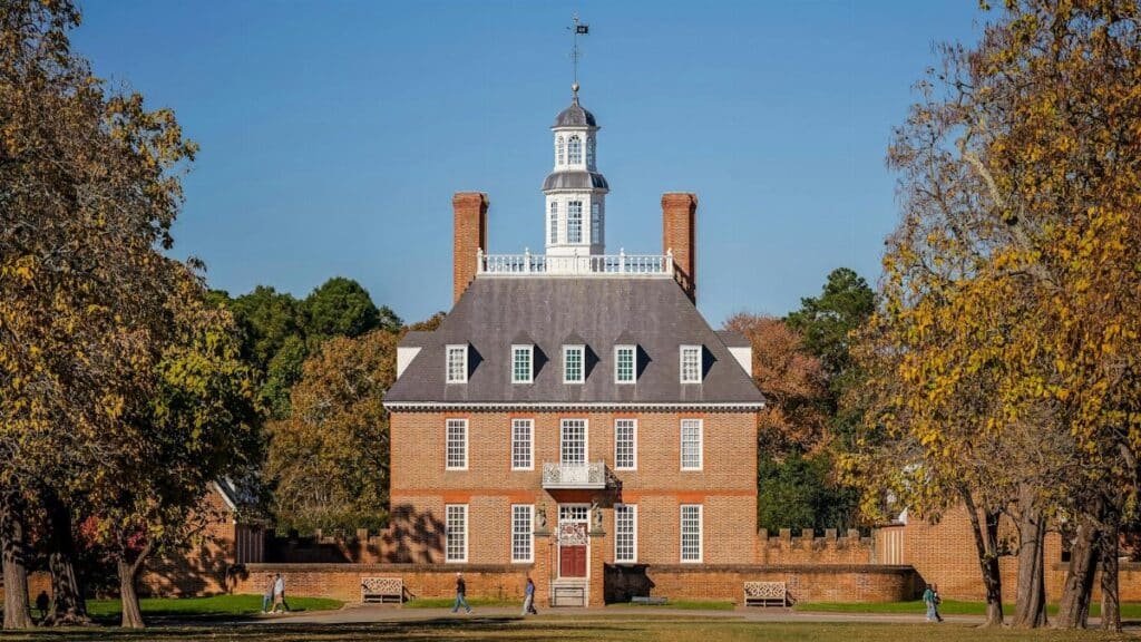 Historic Governor's Palace in Colonial Williamsburg surrounded by autumn foliage.