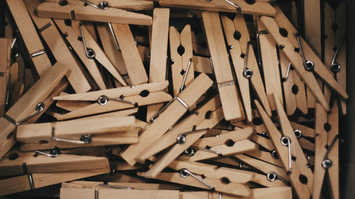 A detailed close-up of a collection of wooden clothespins in a box.