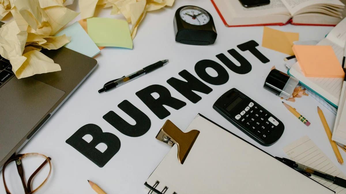 A cluttered office desk symbolizing burnout and stress, with crumpled papers and office supplies.