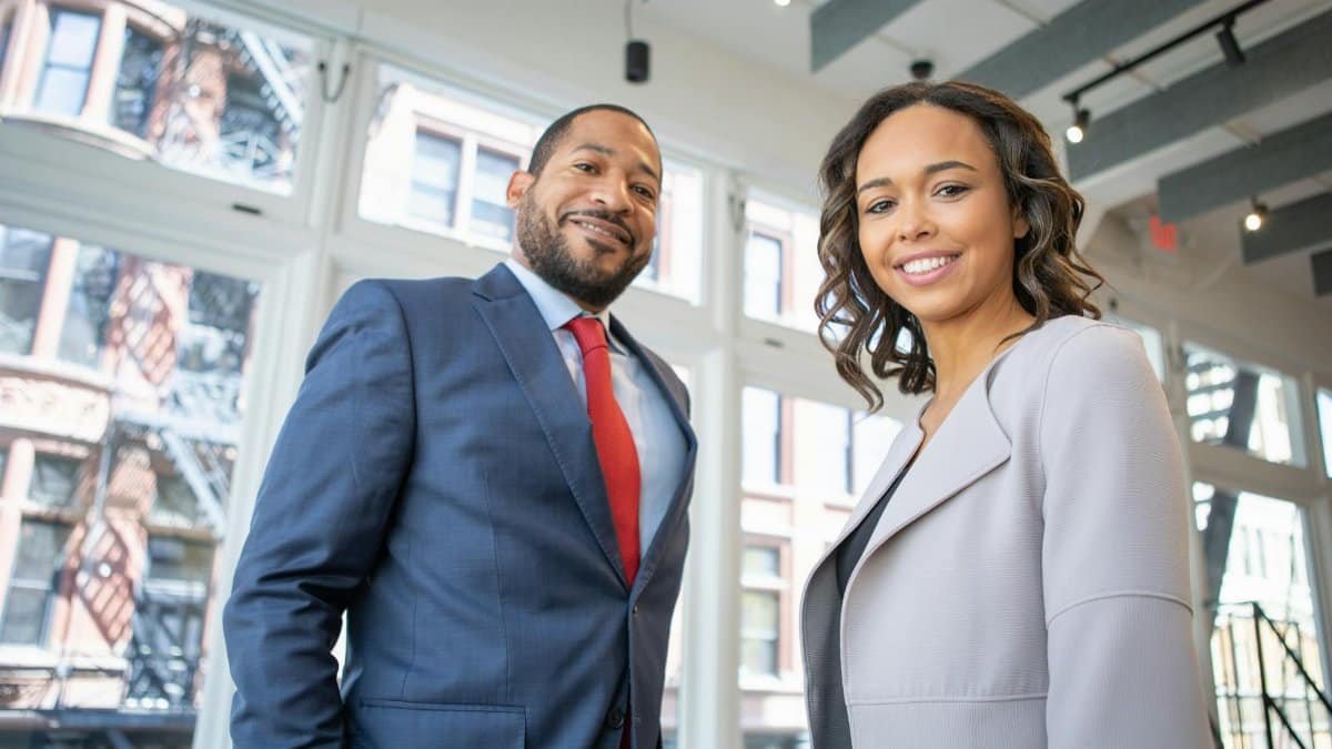 Business professionals smiling in a modern Detroit office setting.