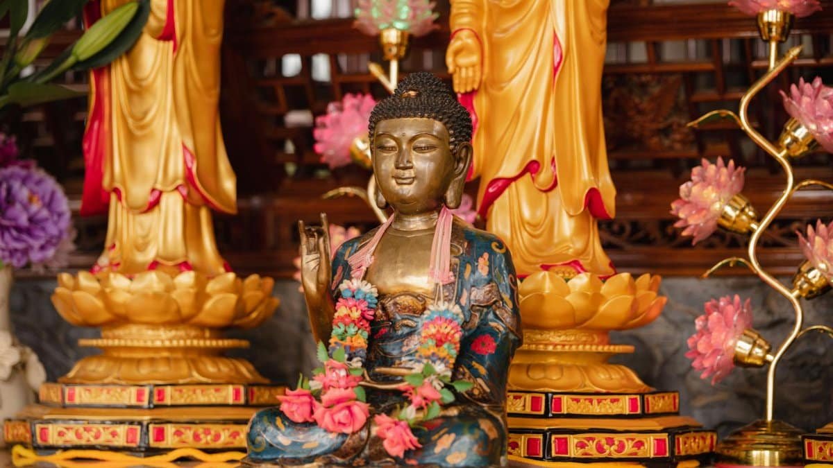 Beautiful Buddha statue surrounded by ornate floral decorations, symbolizing spirituality and peace.