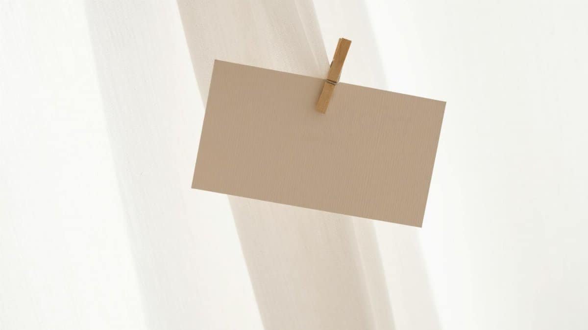 A neutral, minimalist blank card secured by a clothespin against a soft backdrop.