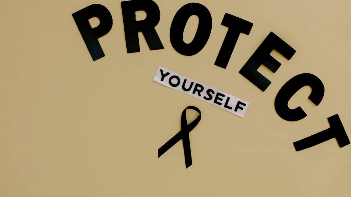 Black ribbon on yellow background with text advocating self-protection and awareness.