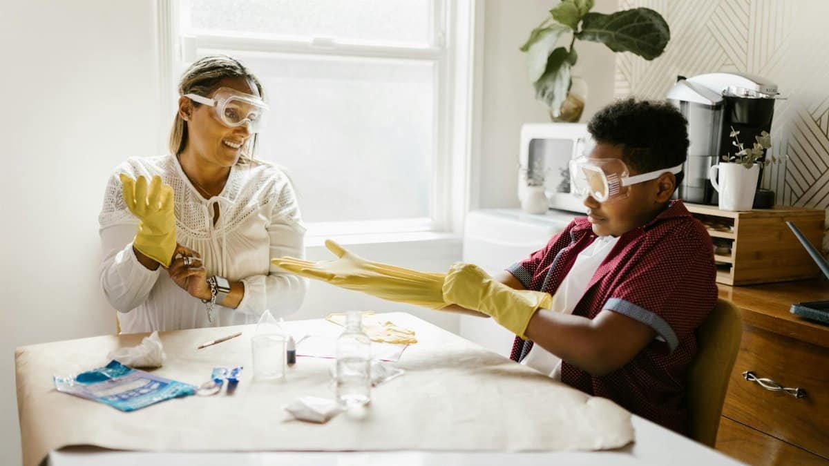 Mother and son engaged in a fun, indoor science experiment using protective goggles and gloves.