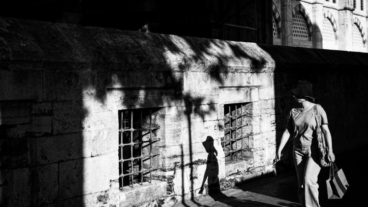 Atmospheric black and white street photo capturing shadows and a solitary figure in Istanbul.