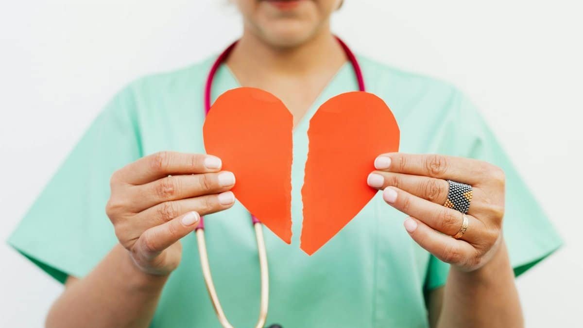 Nurse holding a torn paper heart symbolizing emotional or heart health care.