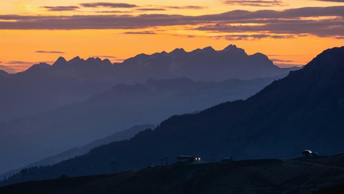 Stunning sunset view of Mont Blanc with layered mountains and vibrant sky.