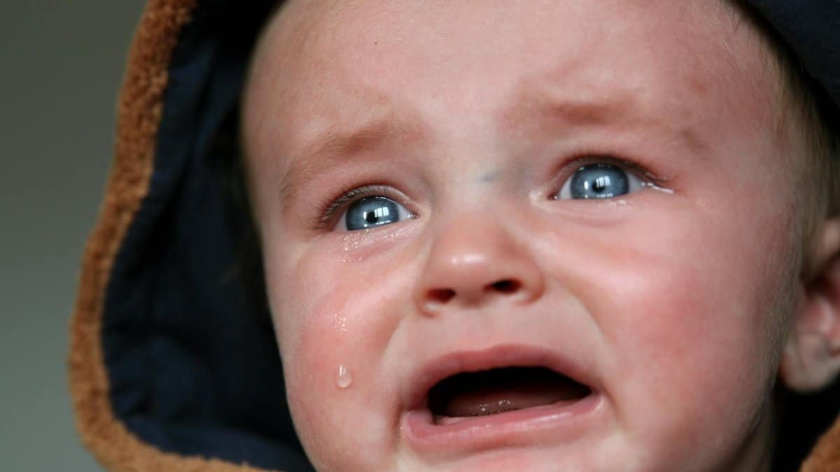 Emotional close-up of a baby in tears, highlighting raw emotion and vulnerability.