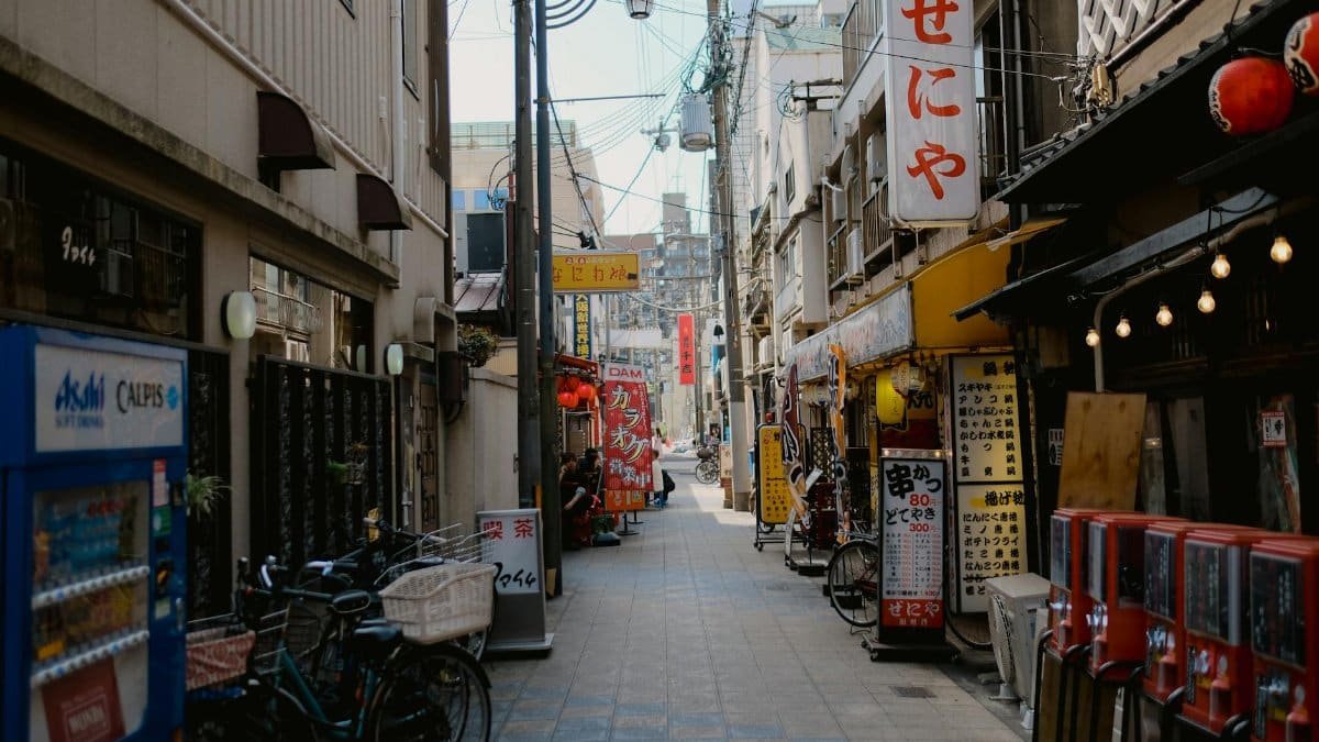 A vibrant urban alley lined with shops and signs, capturing the essence of city life.
