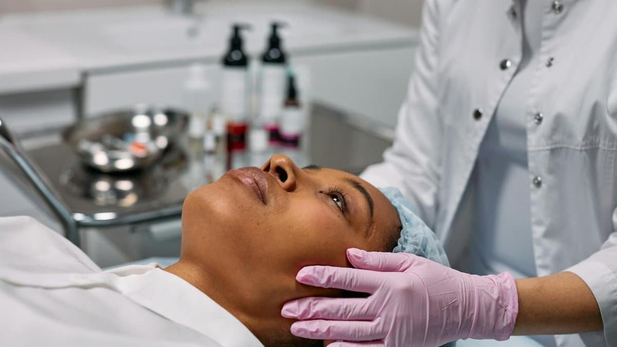 An expert administering a facial treatment to a woman in a modern skincare clinic.