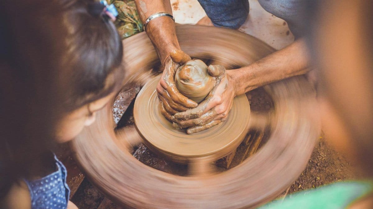 Close-up of hands shaping clay on a pottery wheel, capturing the artistry of crafting.
