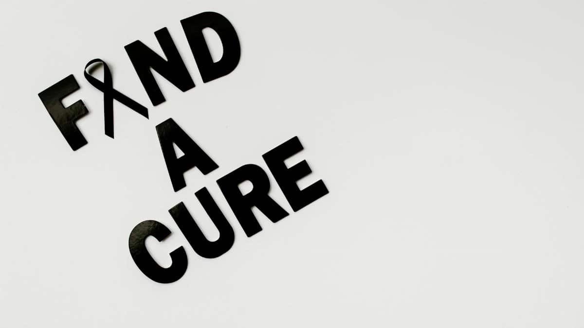 Black text 'Find A Cure' with a cancer awareness ribbon on a white background, symbolizing hope.