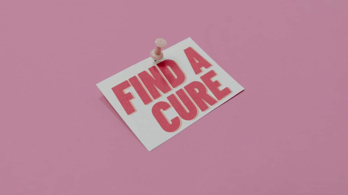 A pink note pinned with message 'Find a Cure', symbolizing cancer awareness.