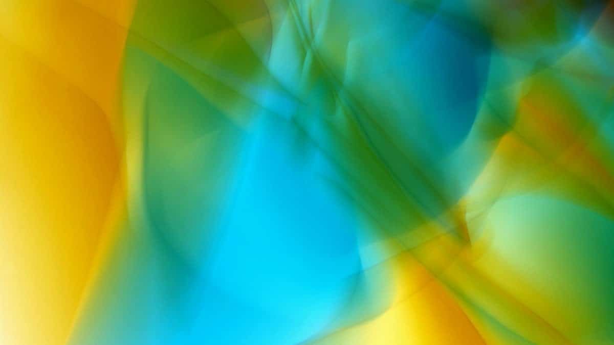 Dynamic abstract image showcasing vibrant blue, yellow, and green flowing patterns.