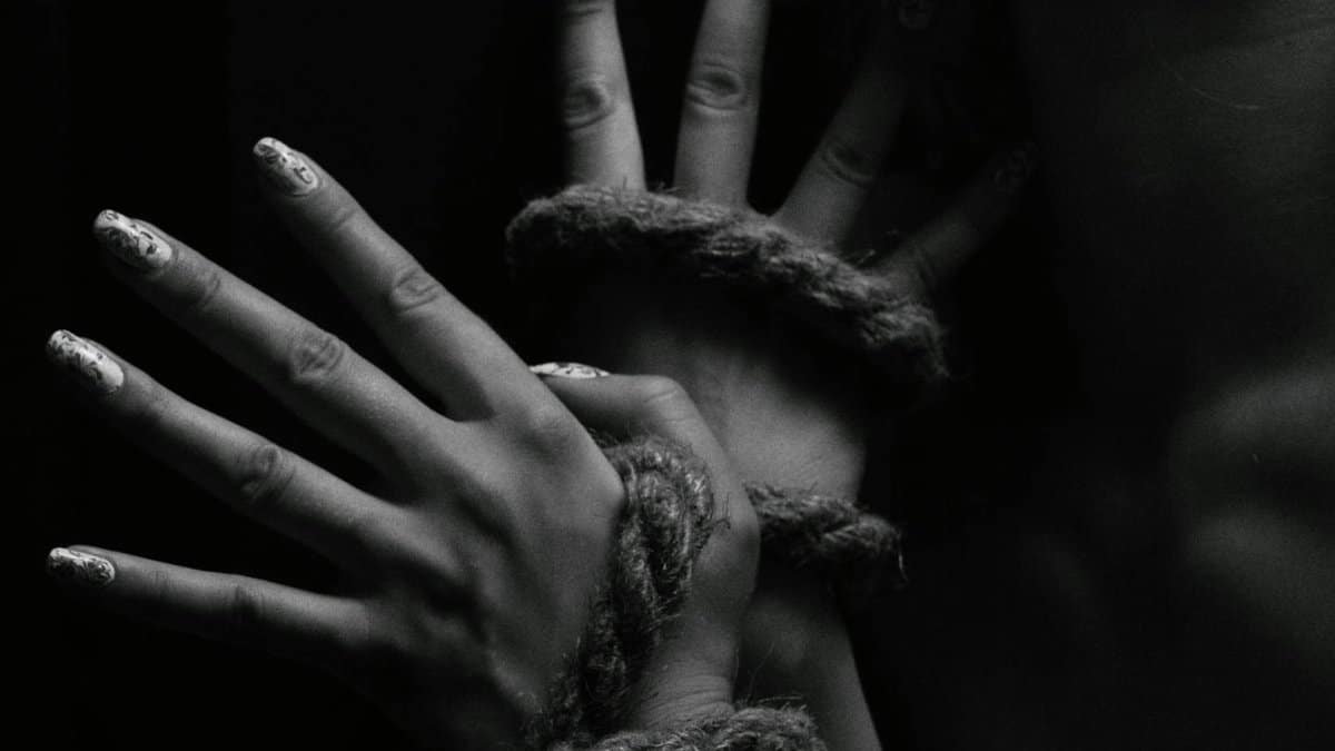 A close-up black and white photo depicting hands creatively bound with rope.