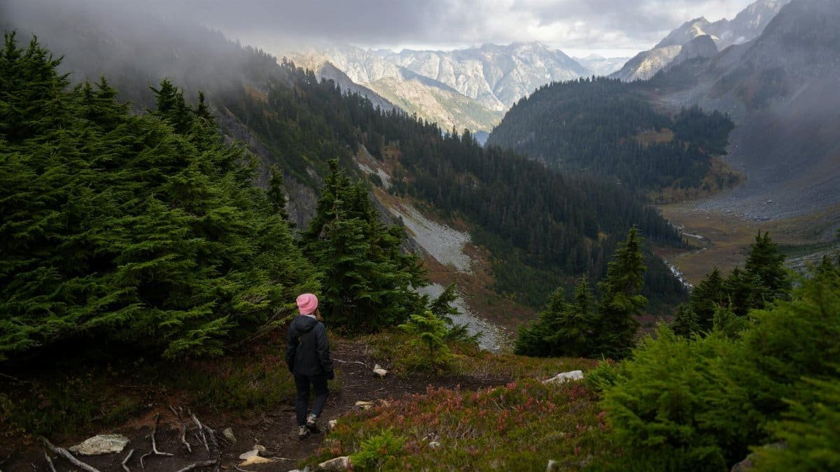 A woman hiking through the misty mountains of North Cascades National Park, Washington.
