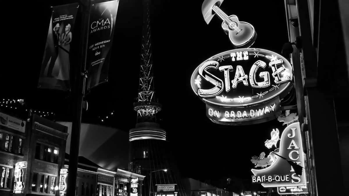 Black and white photo capturing the lively neon-lit signs of Broadway Street, Nashville at night.