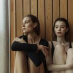 Two women in a sauna, relaxing and reflecting in a modern wellness environment.