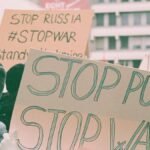 Protest signs at a rally expressing anti-war and anti-Putin sentiments.