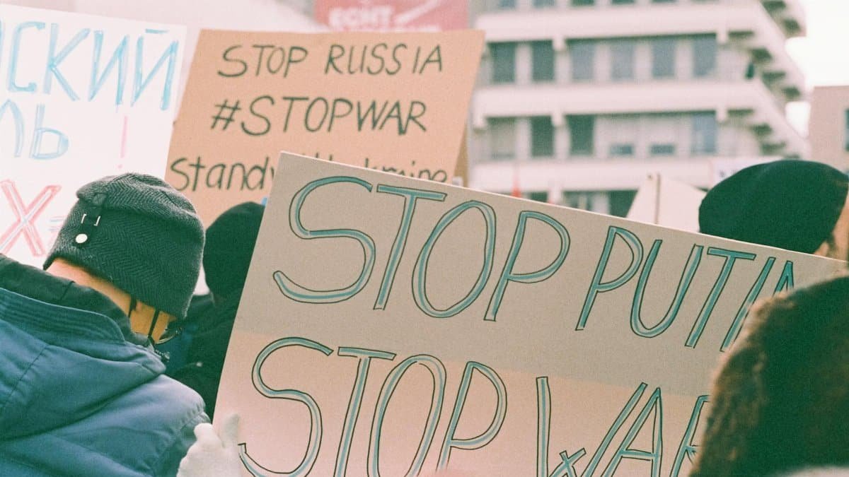 Protest signs at a rally expressing anti-war and anti-Putin sentiments.
