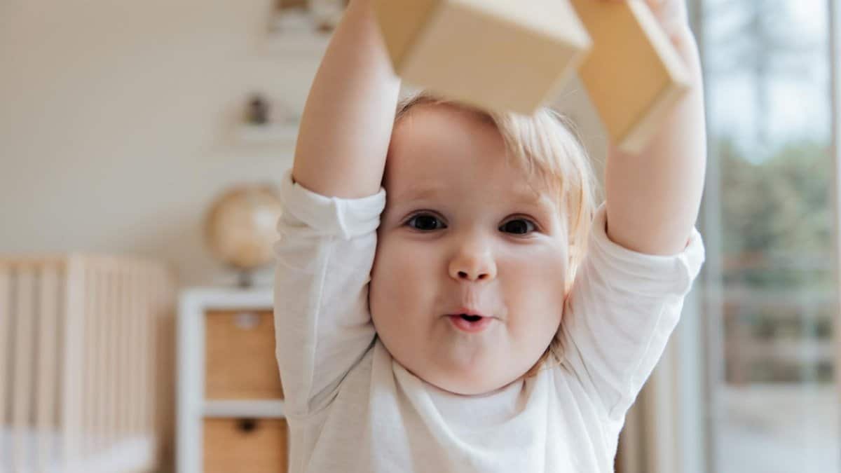 Adorable baby enjoying playtime with wooden blocks in a cozy indoor setting. Perfect depiction of joy and learning.