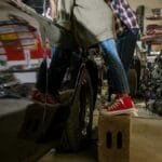 A father and daughter bonding while working on a car in a repair shop, showcasing teamwork and family.