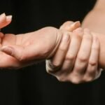 A close-up image of hands grasping a wrist, showcasing human connection and support.