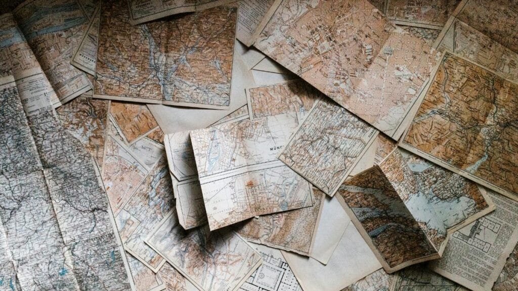 A collection of vintage maps scattered for exploring world journeys and discoveries.