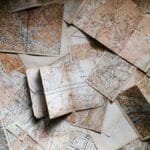 A collection of vintage maps scattered for exploring world journeys and discoveries.