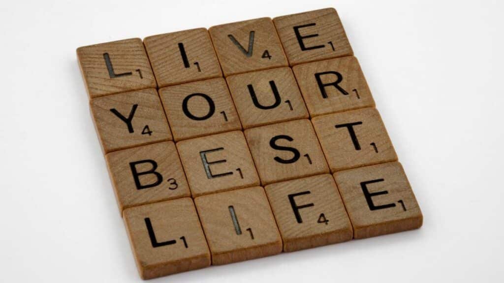 Scrabble tiles arranged to spell 'Live Your Best Life' on a white background.