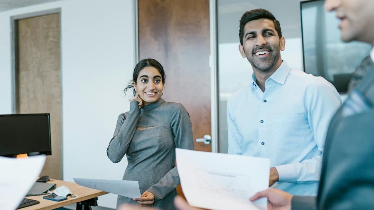 Business professionals engaged in a lively discussion during a team meeting in a modern office.