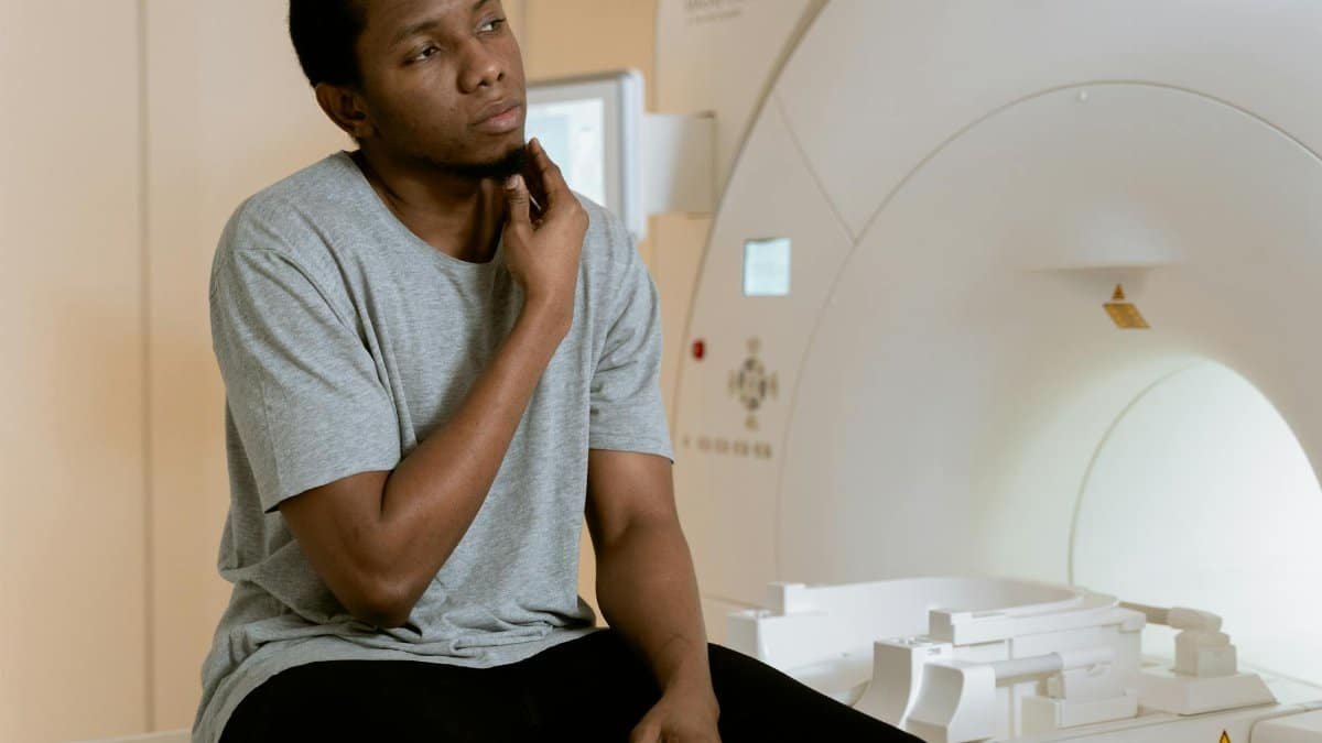 A man sits nervously in an MRI scan room, contemplating his health diagnosis.
