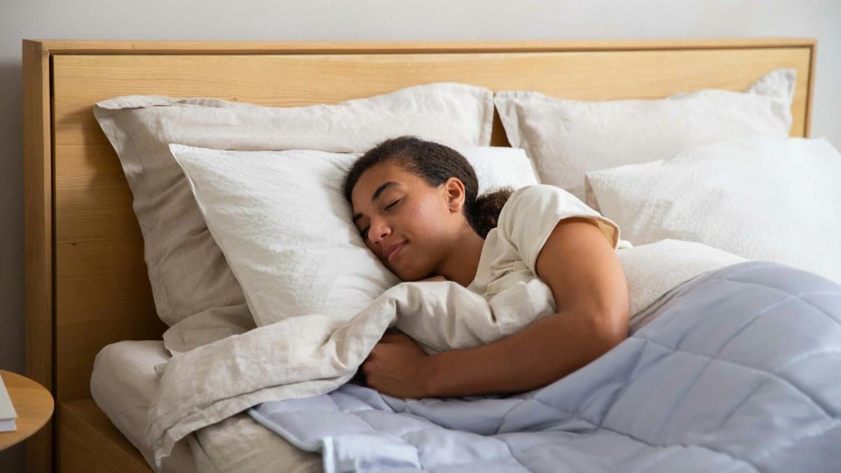 Adult resting under a cozy duvet in a serene bedroom setting promoting relaxation and wellness.