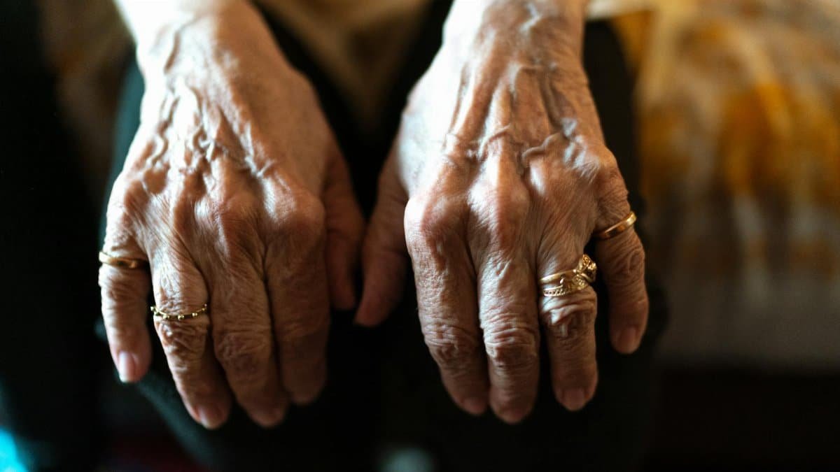 Detailed view of senior hands with rings, symbolizing aging and care