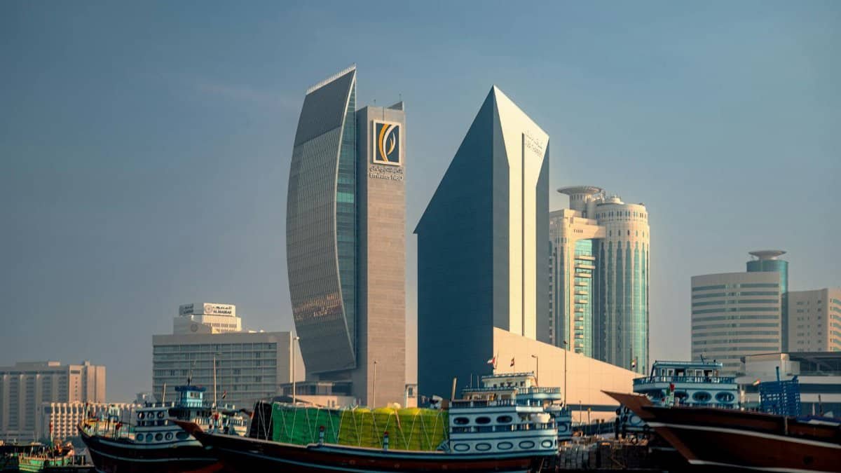 A stunning view of modern skyscrapers contrasted with traditional boats in Dubai's waterways.