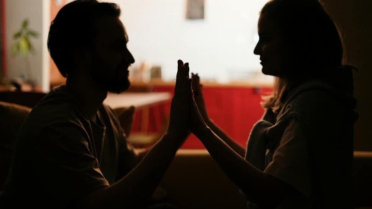 Silhouette of a couple sharing an intimate moment in a cozy home setting. Perfect for love and relationships themes.