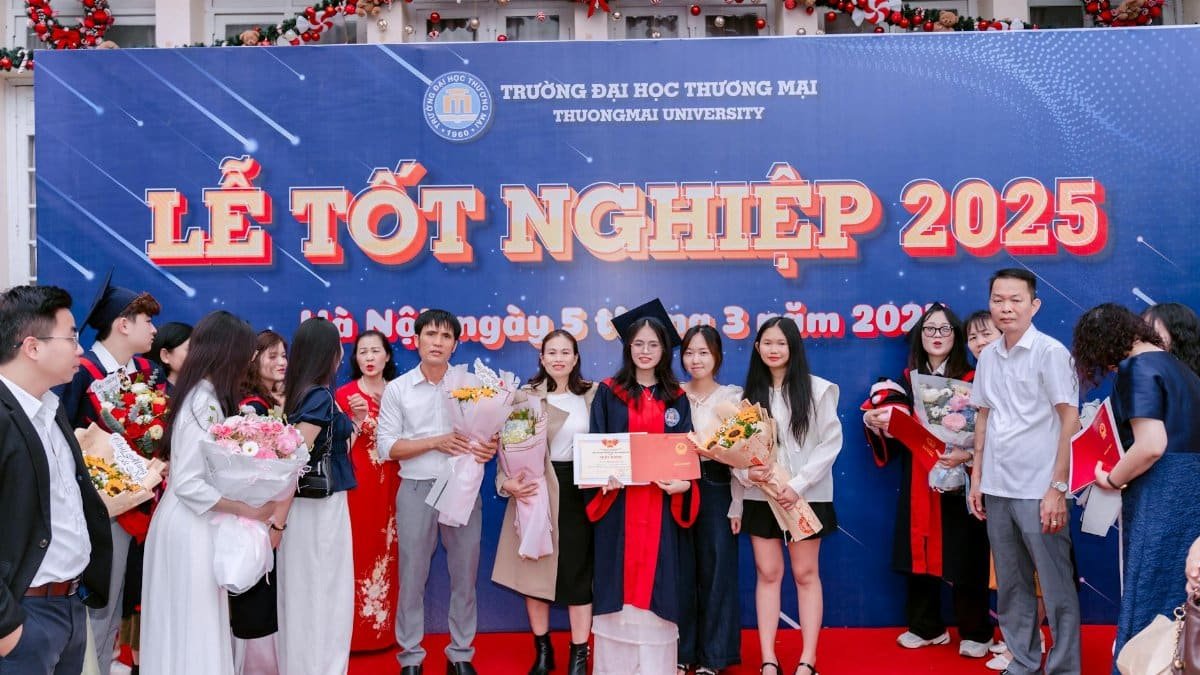 Group of graduates celebrating at Thuongmai University 2025 ceremony.