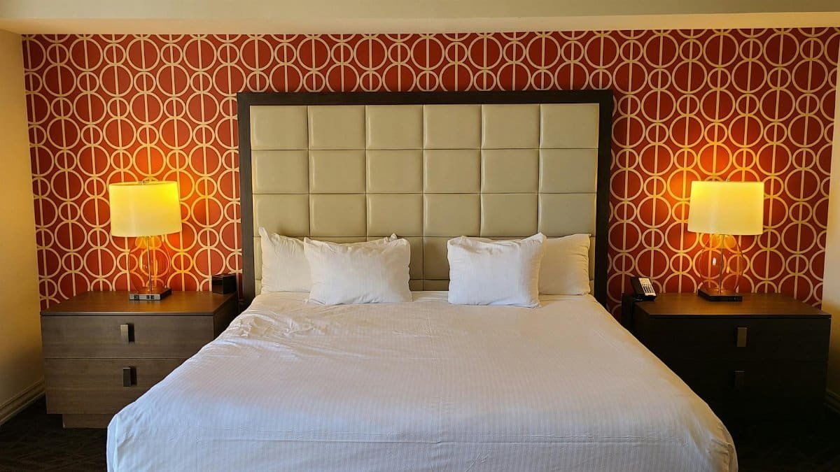 Spacious hotel room in Las Vegas featuring a modern design with a king-size bed and elegant furnishings.