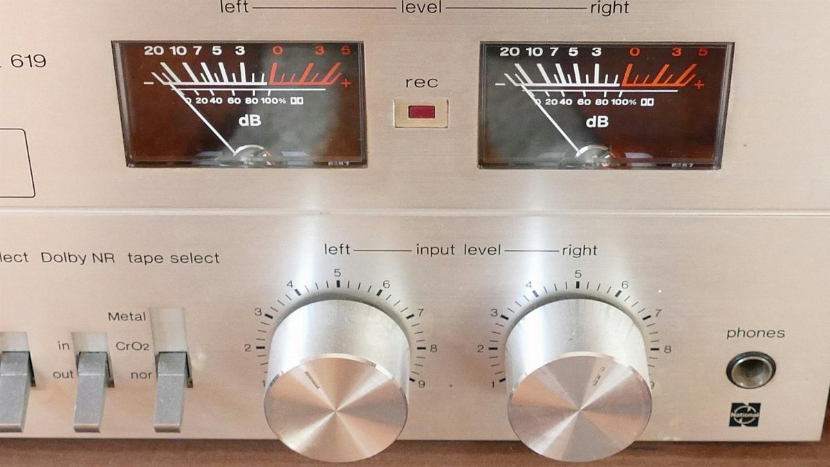 Close-up of a vintage stereo control panel with analog dials and meters.