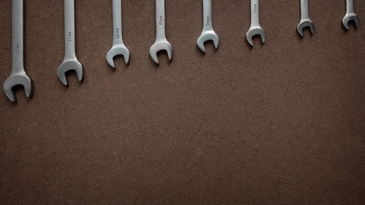 Top view of wrenches lined up on a textured brown surface, showcasing sizes.