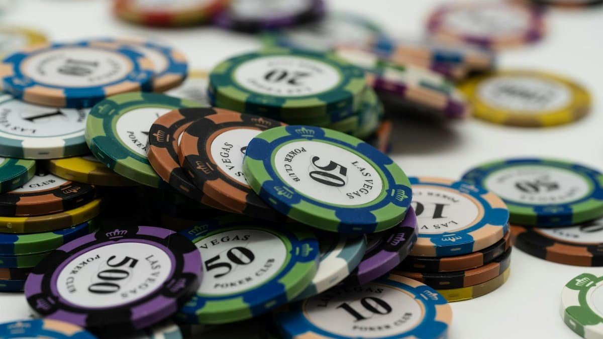 Stacked Las Vegas poker chips showcasing different denominations on a white surface.