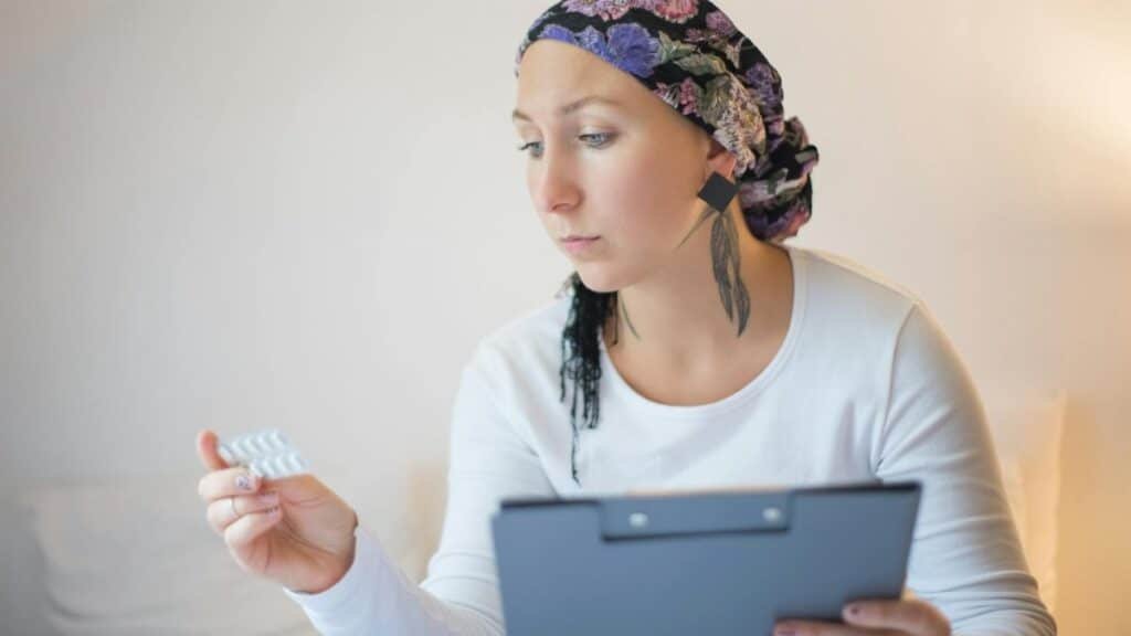 Woman with headscarf in bedroom reviews medication, symbolizing hope and recovery.